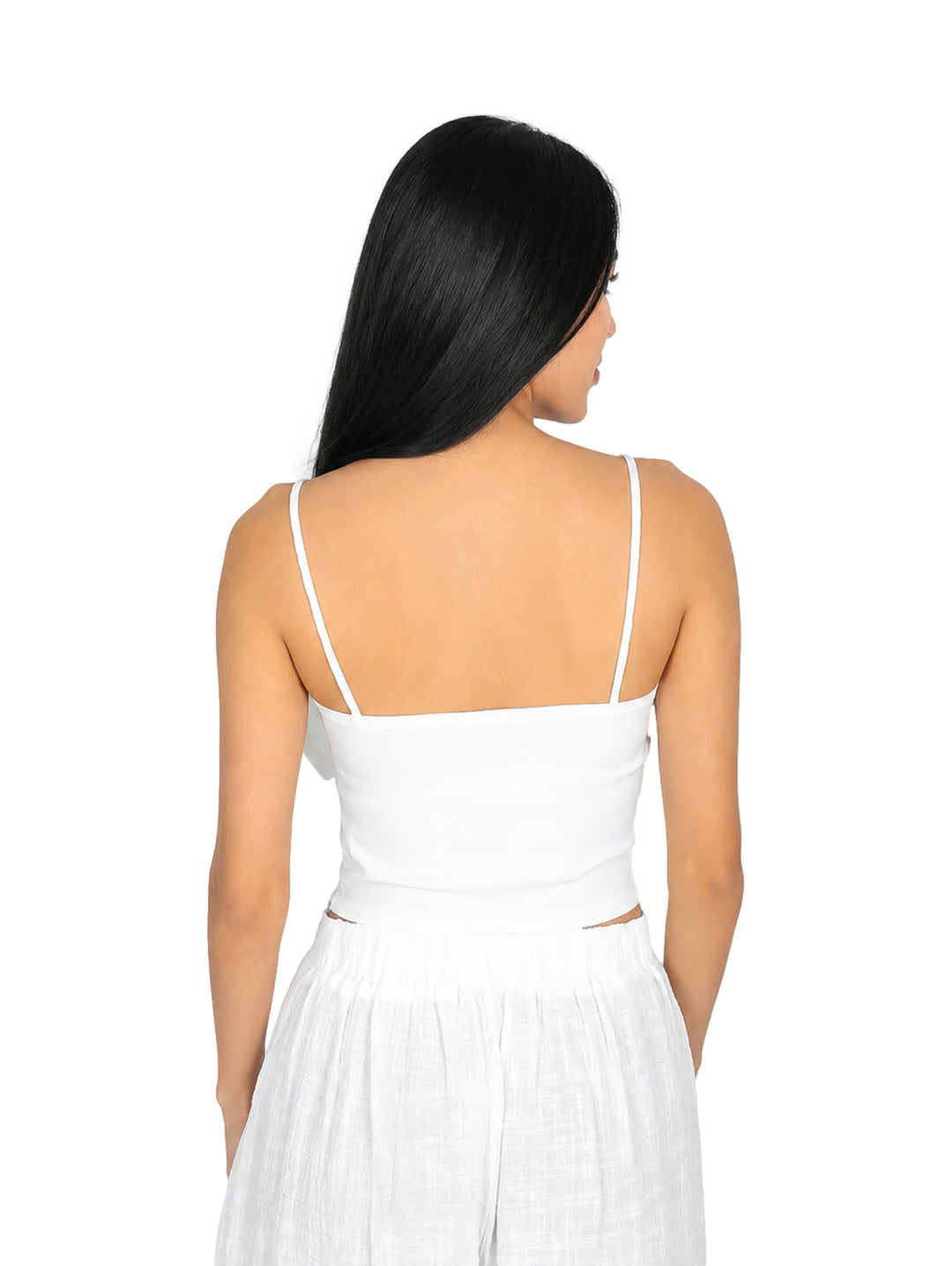 Blusa blanca corta con un moño grande en el frente y tirantes delgados.