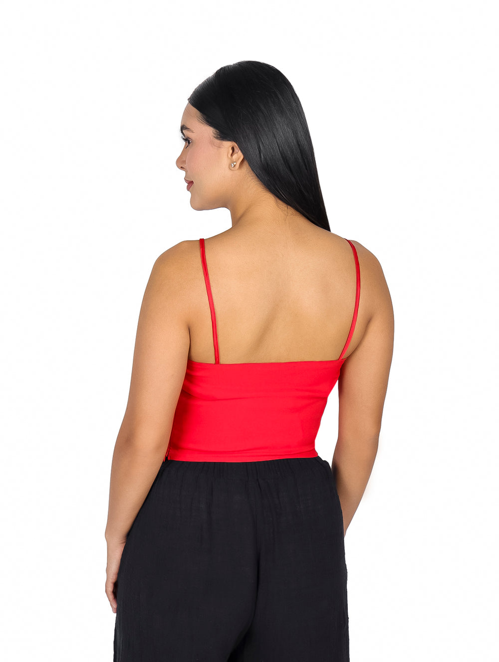 Mujer vistiendo blusa roja de tirantes con un moño grande decorativo en el pecho.