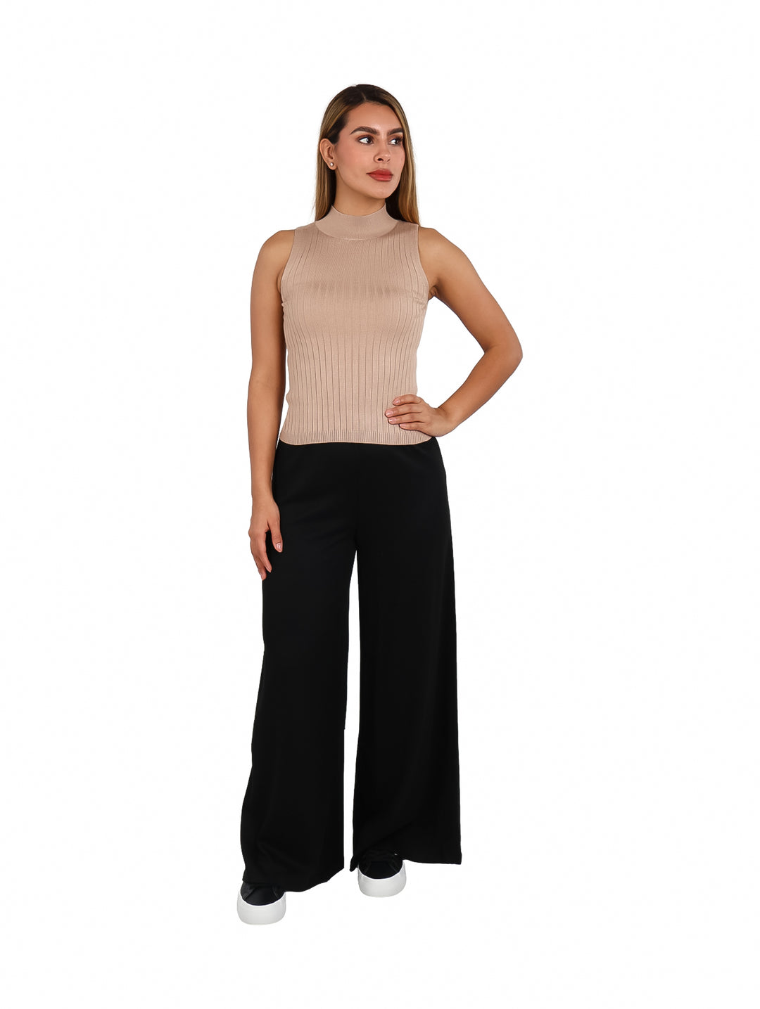 Mujer modelando blusa sin mangas color beige con cuello alto y pantalones negros.