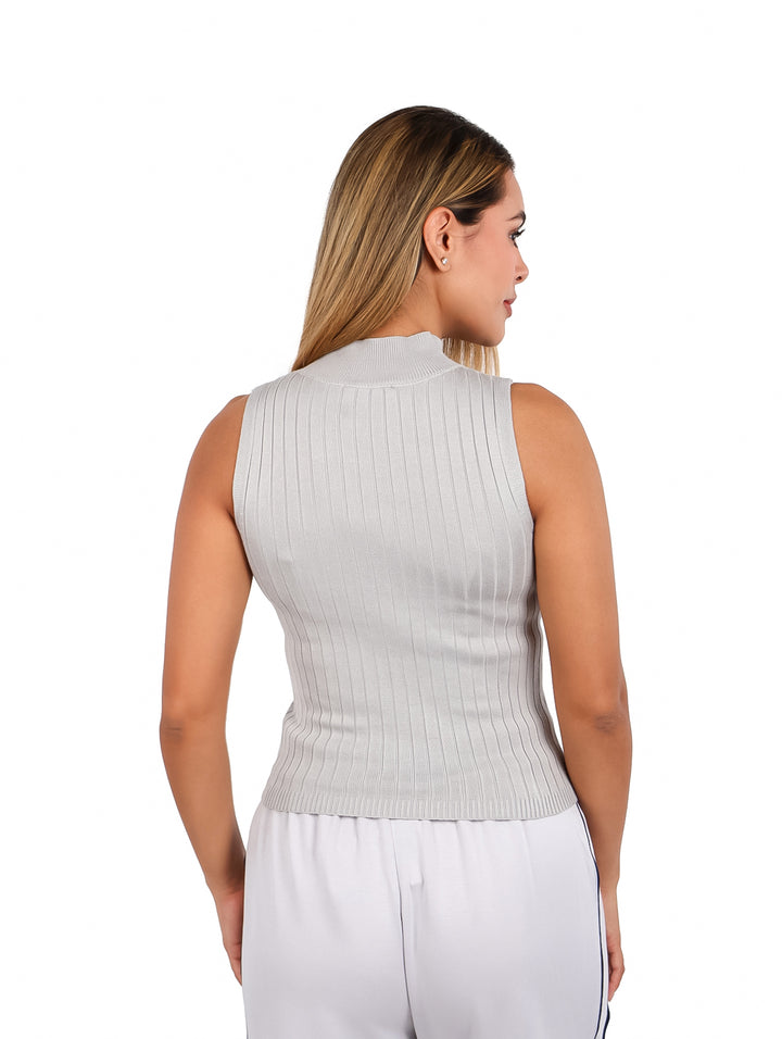 Mujer modelando una blusa gris sin mangas de cuello alto y textura acanalada.
