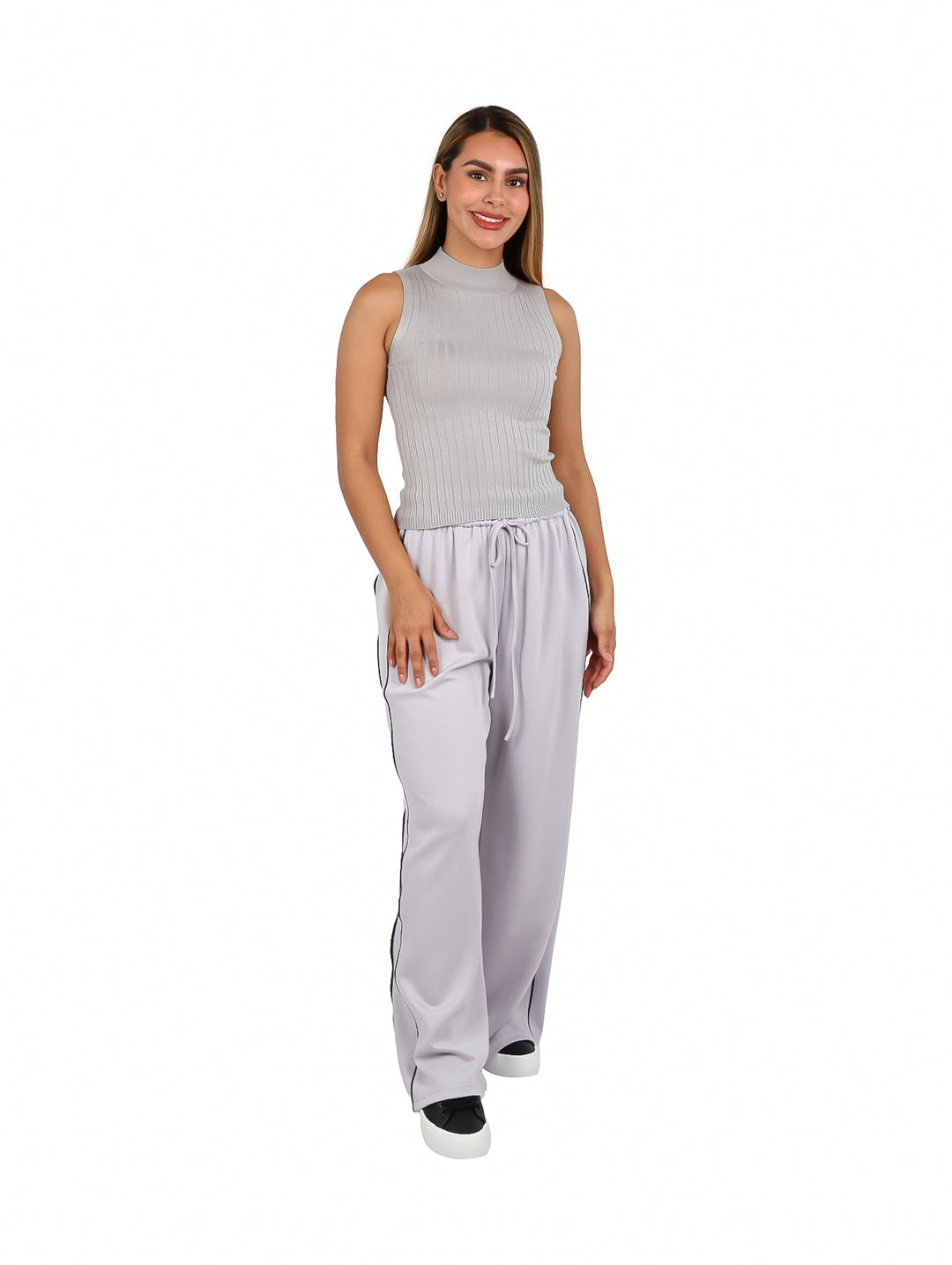 Mujer modelando una blusa gris sin mangas de cuello alto y textura acanalada.