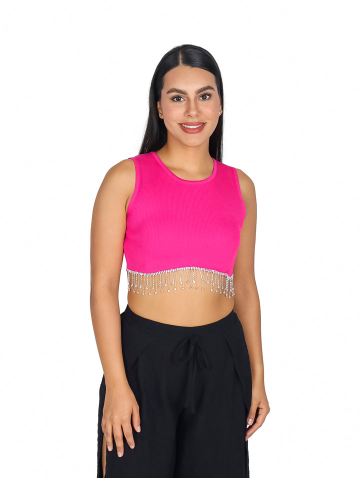 Mujer vistiendo un top corto color fucsia con detalles de flecos brillantes en el borde inferior.