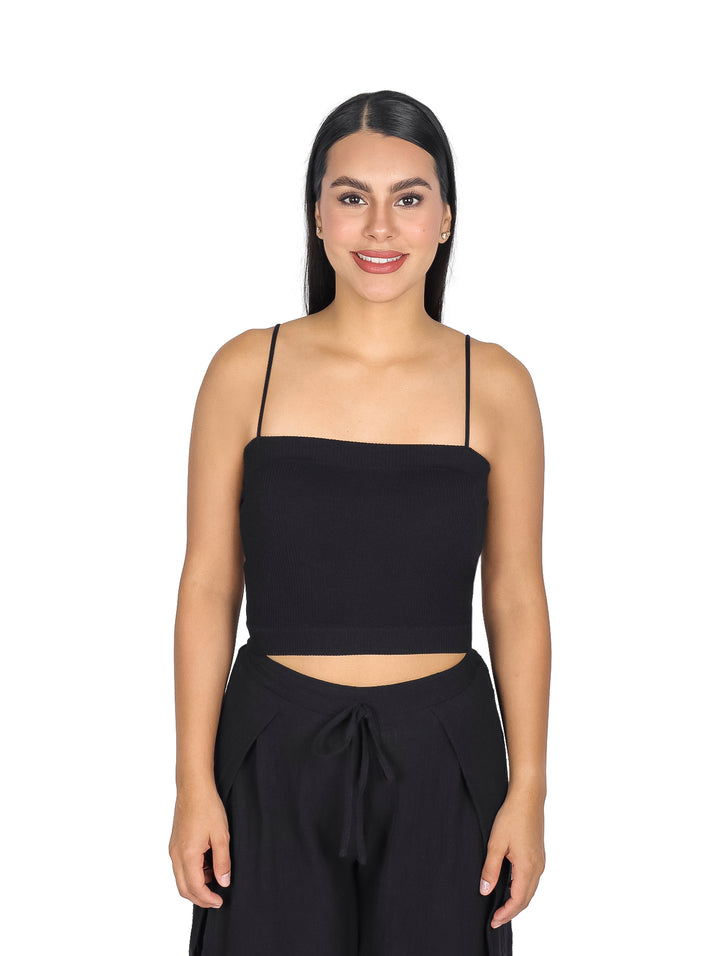 Mujer vistiendo una blusa negra sin mangas estilo crop top.