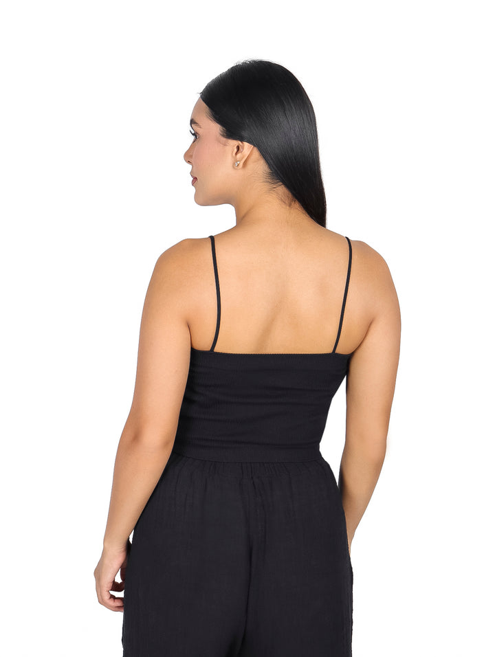 Mujer vistiendo una blusa negra sin mangas estilo crop top.