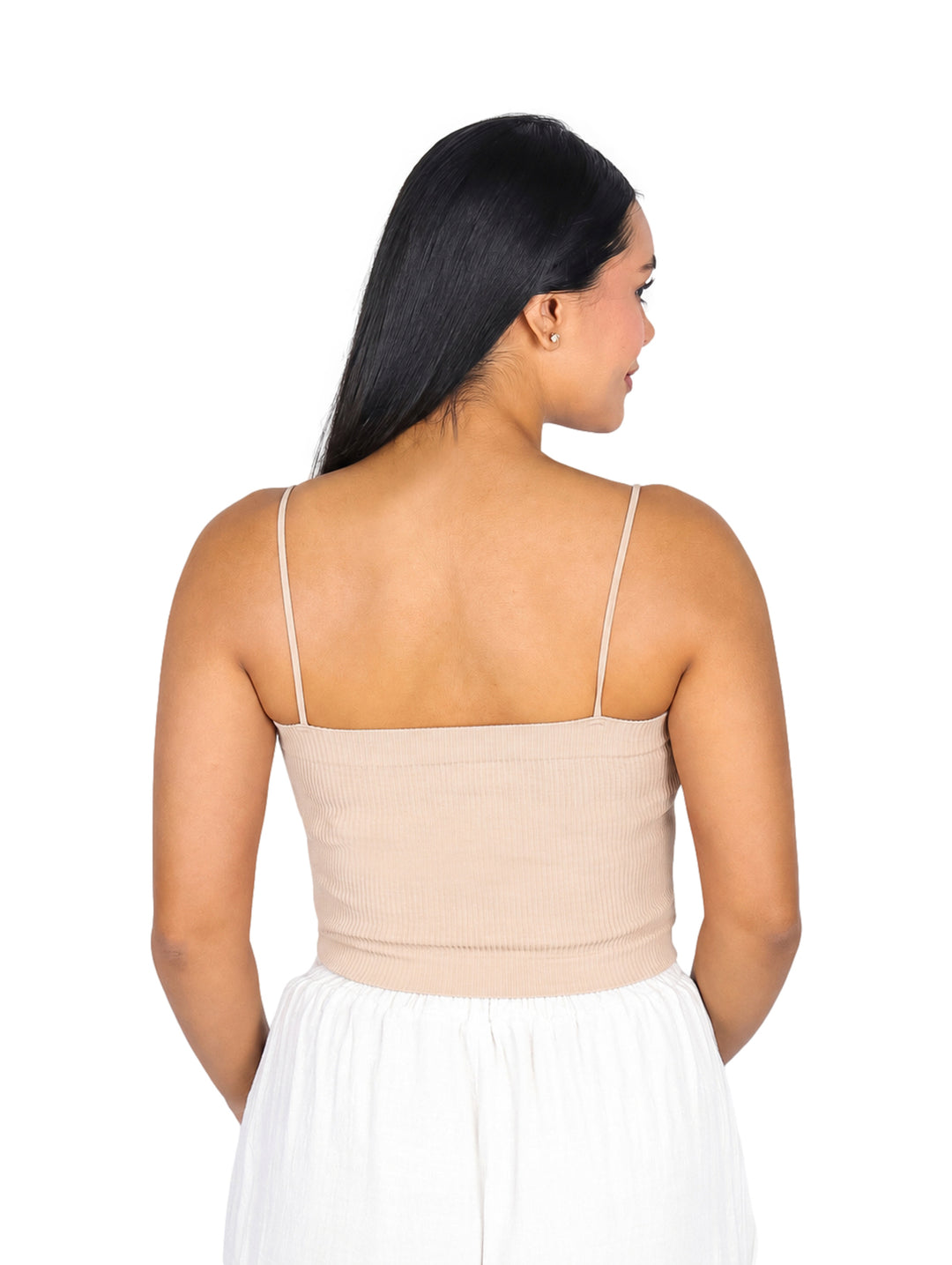 Mujer modelando blusa crop top color camel con tirantes delgados y pantalones blancos.