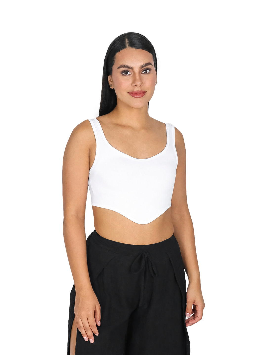 Mujer vistiendo un top tipo corset blanco corto y pantalones negros.