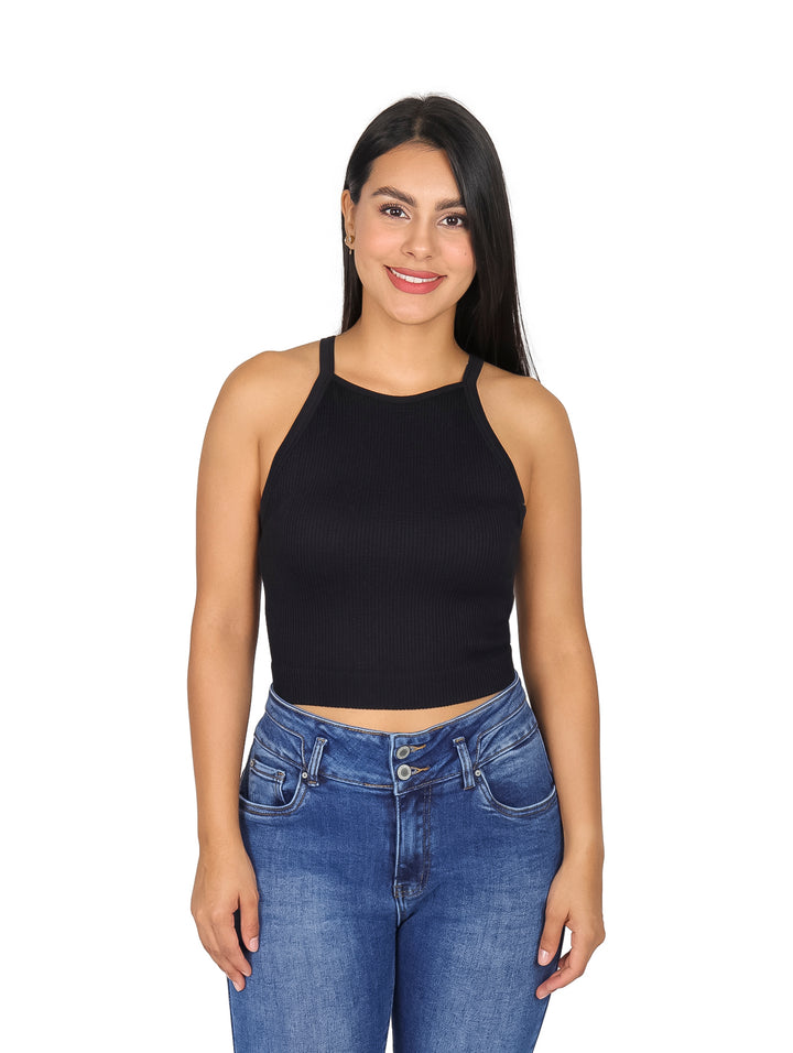 Mujer vistiendo blusa negra sin mangas de cuello halter y pantalones vaqueros azules.