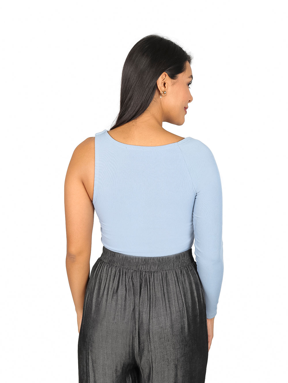Mujer vistiendo blusa azul claro asimétrica de una sola manga y pantalones grises.