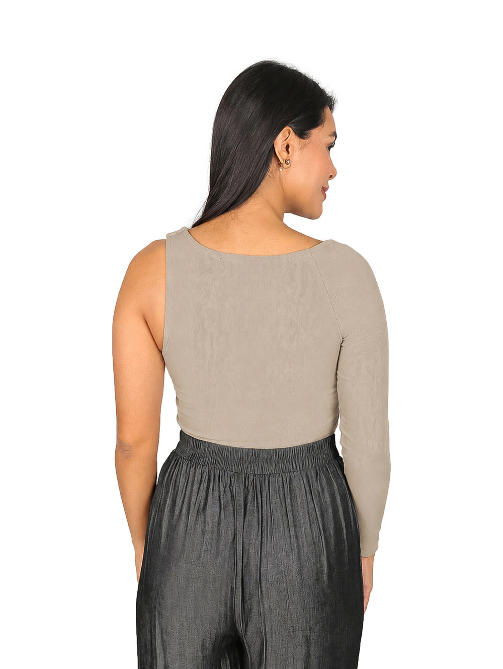 Mujer vistiendo blusa asimétrica de una sola manga en color camel y pantalones grises.