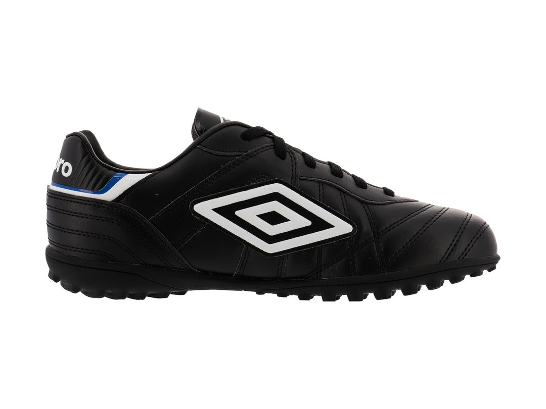 Zapato de fútbol Umbro color negro con detalles en blanco y azul y suela para césped sintético.