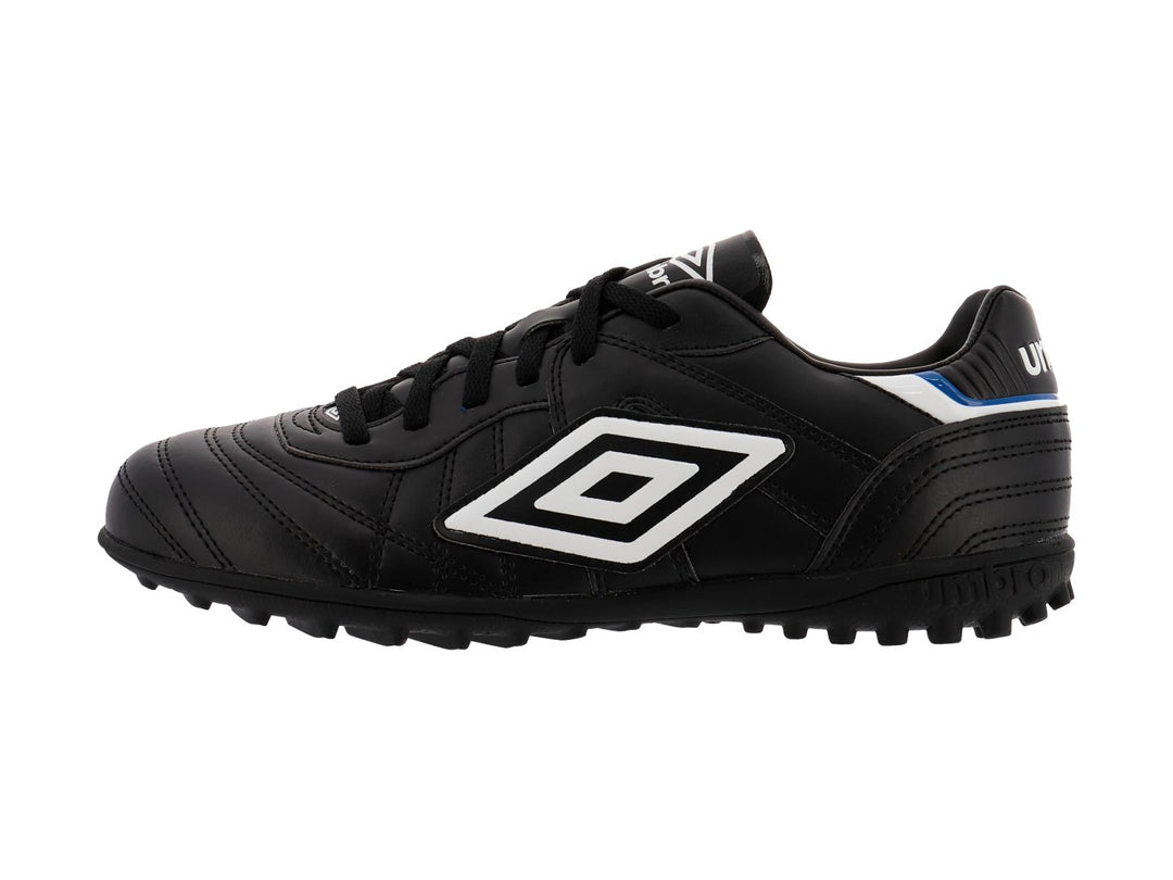 Zapato de fútbol Umbro color negro con detalles en blanco y azul y suela para césped sintético.