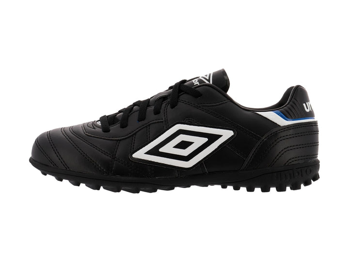 Zapato de fútbol Umbro color negro con detalles en blanco y azul y suela para césped sintético.