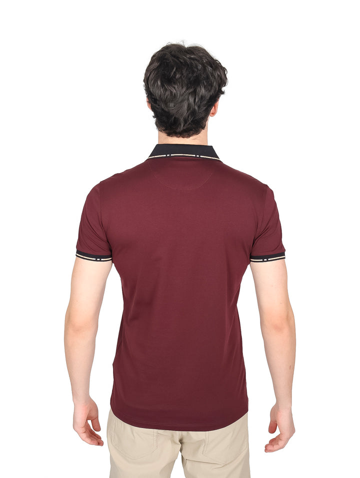 Hombre vistiendo una playera polo color burgundy con cuello y detalles en negro.