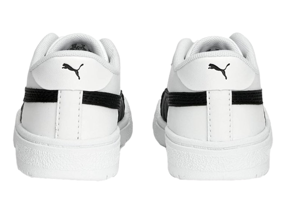 Tenis PUMA blancos con franja negra lateral y suela blanca para niños.