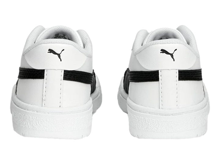 Tenis PUMA blancos con franja negra lateral y suela blanca para niños.