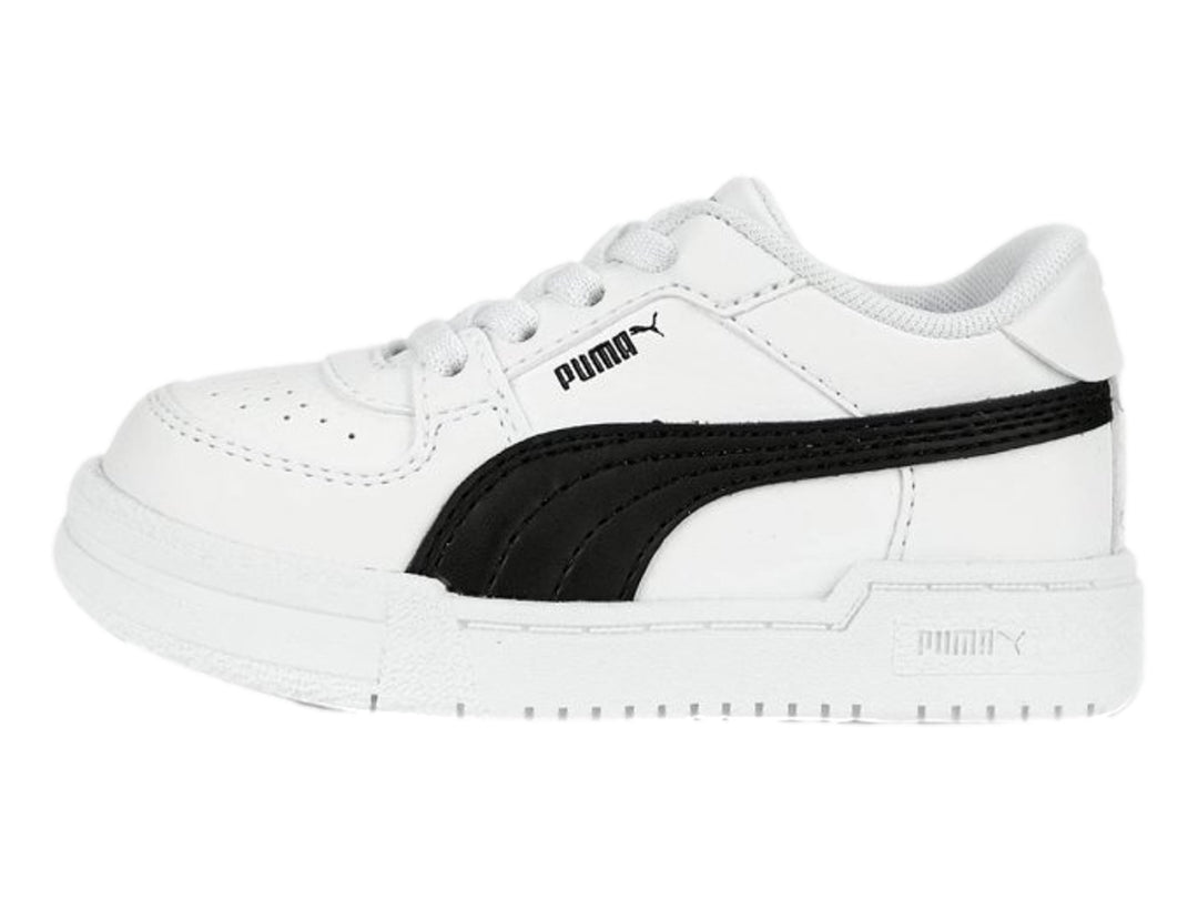 Tenis PUMA blancos con franja negra lateral y suela blanca para niños.