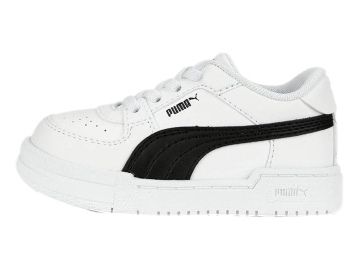 Tenis PUMA blancos con franja negra lateral y suela blanca para niños.