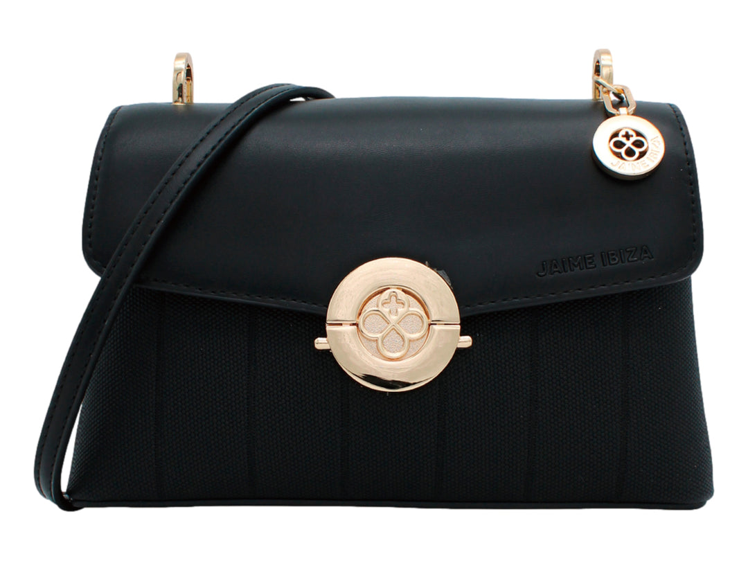 Bolso negro de Jaime Ibiza con cierre circular dorado y cuerpo con textura acanalada.