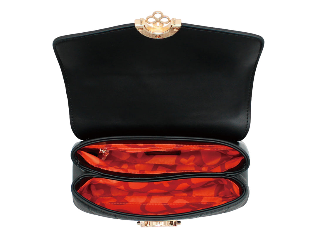 Bolso negro de Jaime Ibiza con cierre circular dorado y cuerpo con textura acanalada.
