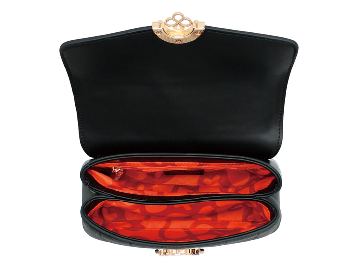 Bolso negro de Jaime Ibiza con cierre circular dorado y cuerpo con textura acanalada.