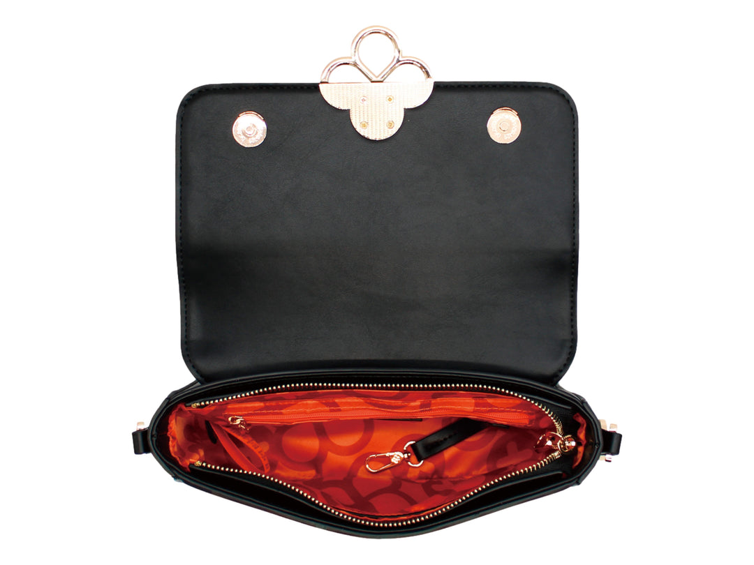 Bolso negro rectangular con herraje dorado decorativo frontal y correa larga.