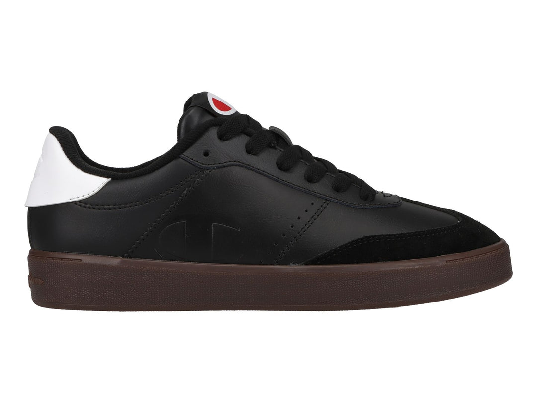 Tenis Champion color negro con suela color goma y detalle blanco en el talón.