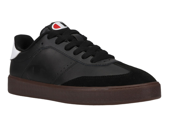 Tenis Champion color negro con suela color goma y detalle blanco en el talón.