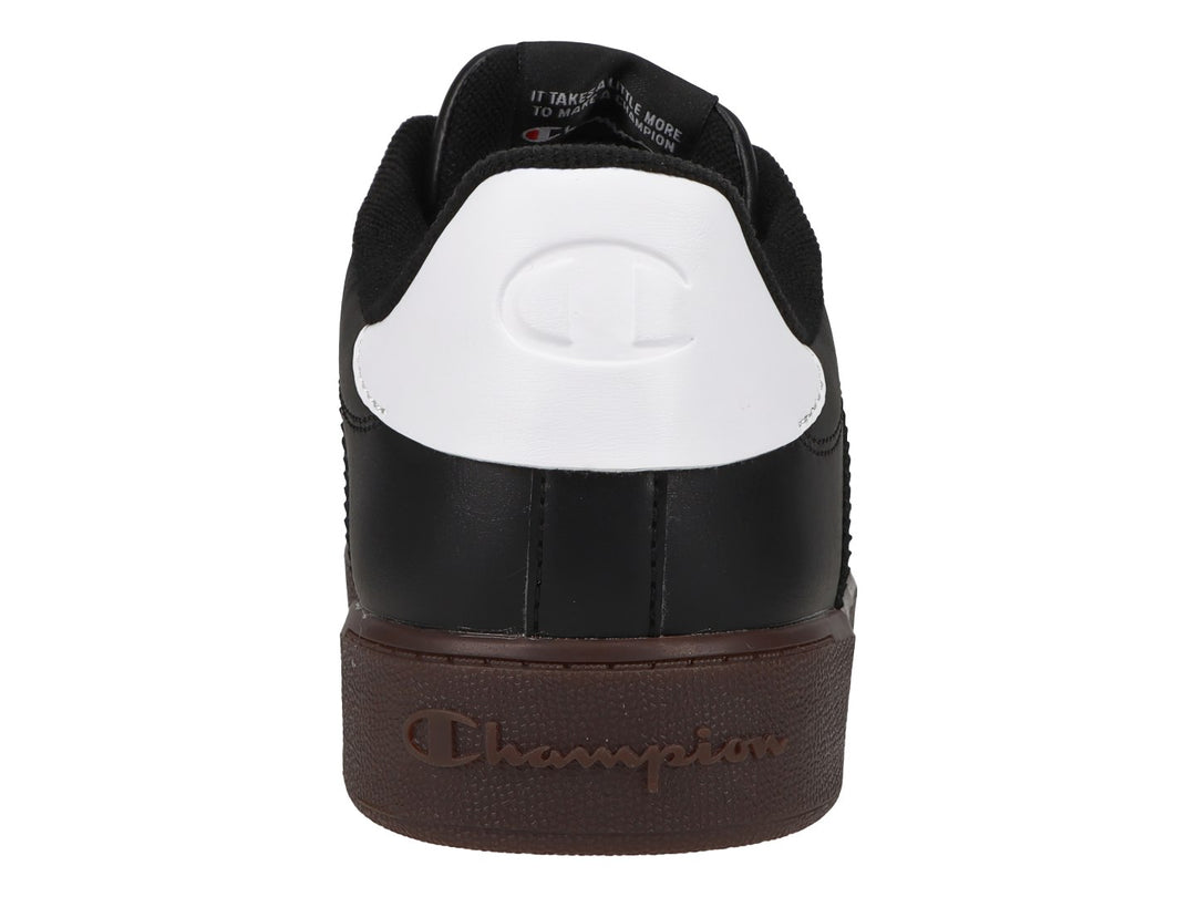 Tenis Champion color negro con suela color goma y detalle blanco en el talón.