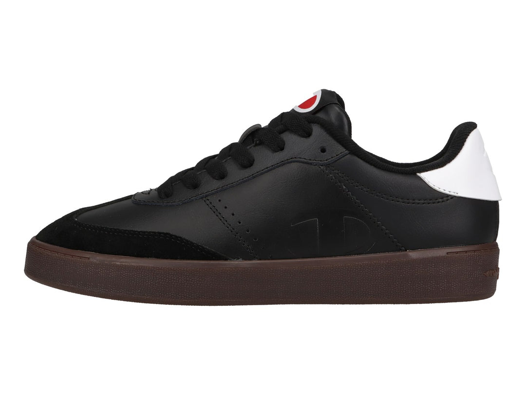 Tenis Champion color negro con suela color goma y detalle blanco en el talón.