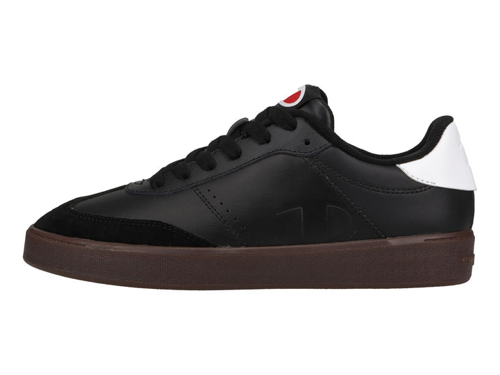 Tenis Champion color negro con suela color goma y detalle blanco en el talón.