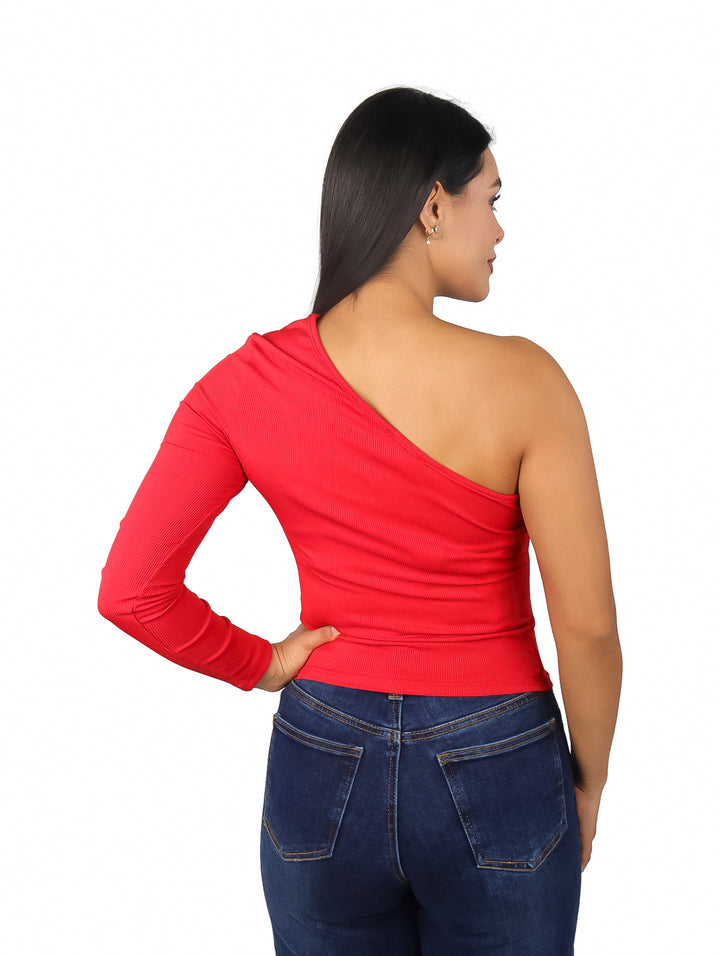 Mujer vistiendo blusa roja de una sola manga y pantalones vaqueros azules.