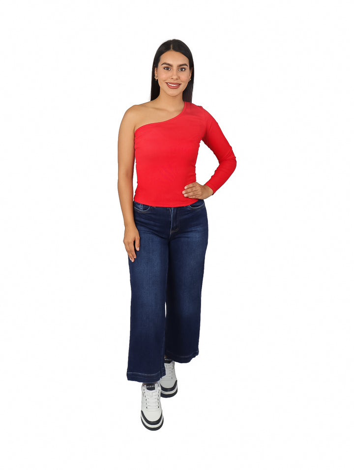 Mujer vistiendo blusa roja de una sola manga y pantalones vaqueros azules.