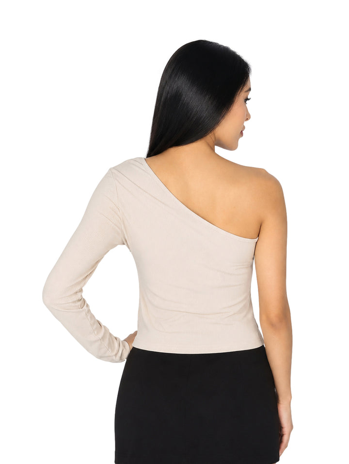 Mujer modelando blusa color crema asimétrica de un solo hombro y falda negra.