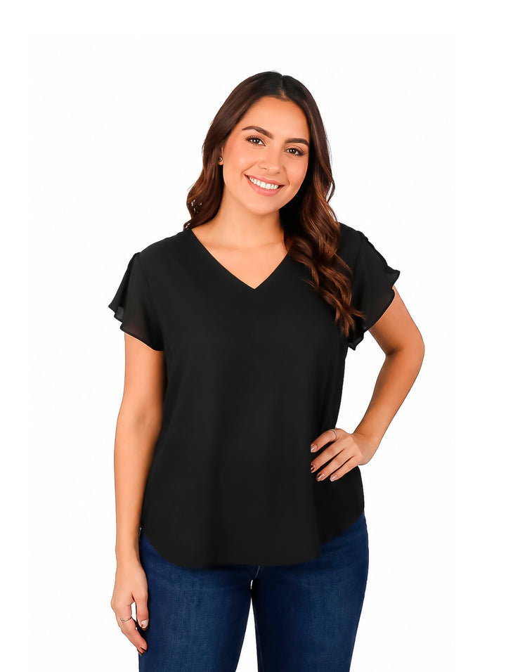 Mujer modelando blusa negra de cuello en V y jeans azules sobre fondo blanco.