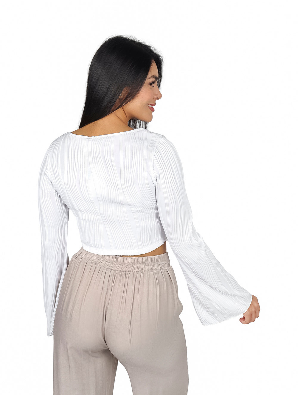Mujer vistiendo blusa blanca con mangas campana y textura plisada