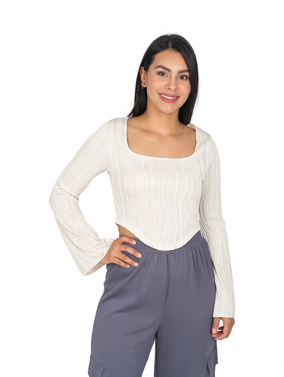 Mujer vistiendo blusa beige de cuello cuadrado y mangas campana con textura acanalada.