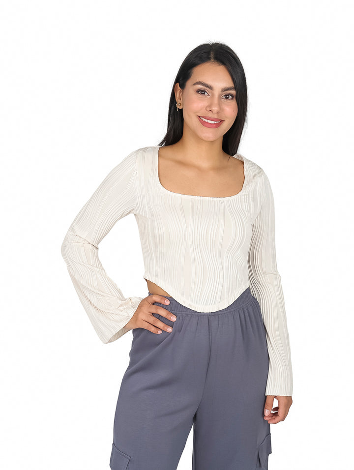 Mujer vistiendo blusa beige de cuello cuadrado y mangas campana con textura acanalada.