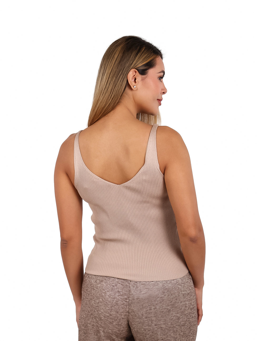 Mujer vistiendo una blusa sin mangas color beige con textura acanalada.