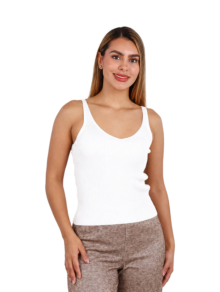 Mujer vistiendo una blusa blanca sin mangas de cuello redondo y textura acanalada.