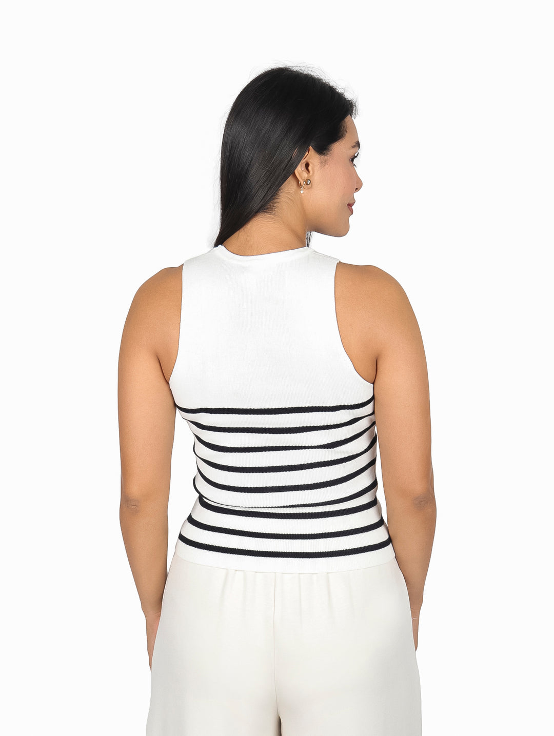 Mujer vistiendo blusa blanca sin mangas con rayas horizontales negras.