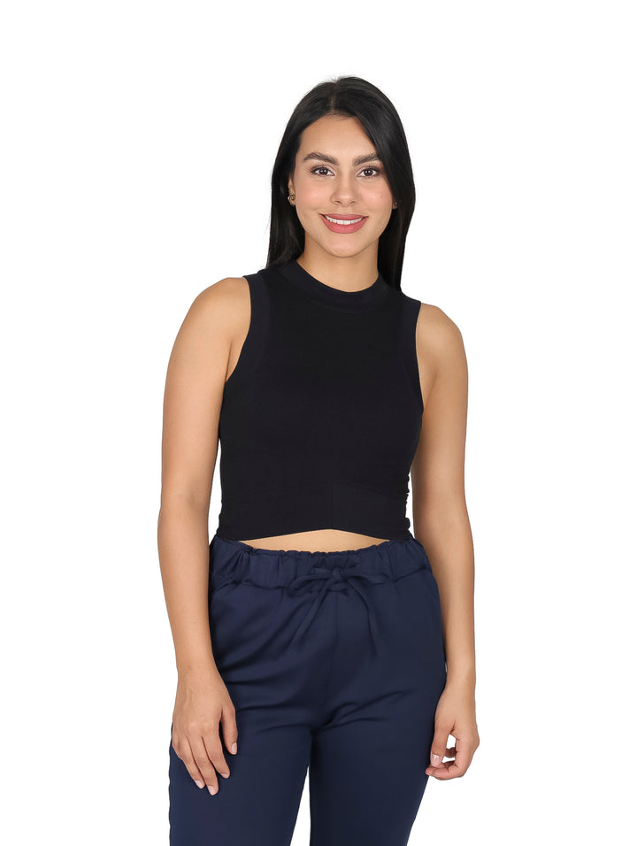 Mujer vistiendo un top negro sin mangas de cuello redondo y pantalones azul marino.