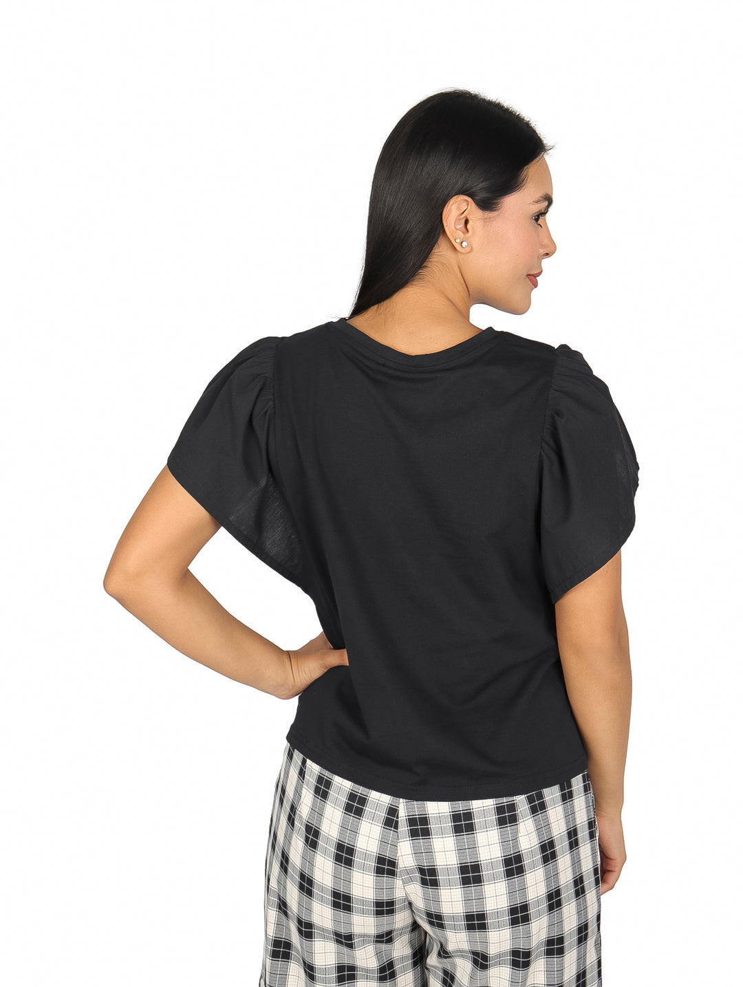 Mujer vistiendo una blusa negra de manga corta con detalle de escarlola y pantalones a cuadros.