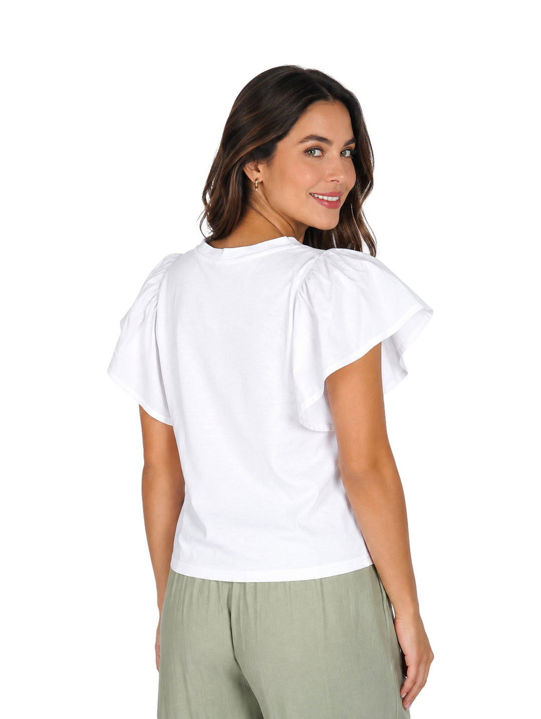 Mujer vistiendo blusa blanca de manga corta con detalles de escarola y pantalones color verde claro.