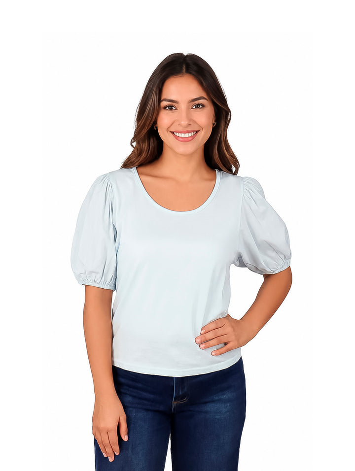 Mujer vistiendo una blusa color azul claro con mangas globo y cuello redondo.