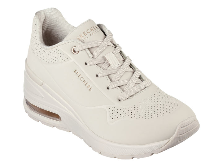 Tenis Skechers Million Air One en color hueso con suela amortiguada y detalles perforados.