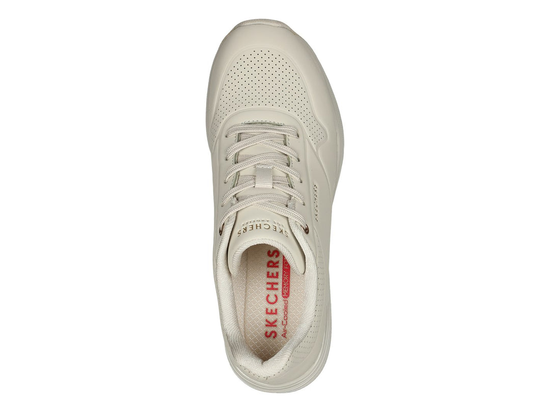 Tenis Skechers Million Air One en color hueso con suela amortiguada y detalles perforados.