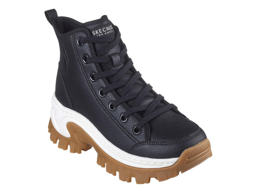 Botín Skechers negro de caña media con suela gruesa color café y detalle blanco en la entresuela.