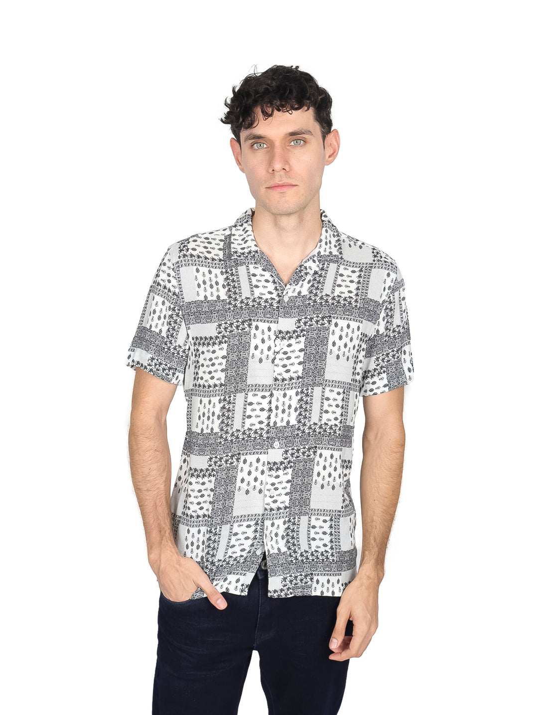 Hombre vistiendo camisa de manga corta color blanco con estampado geométrico en negro, estilo resort.