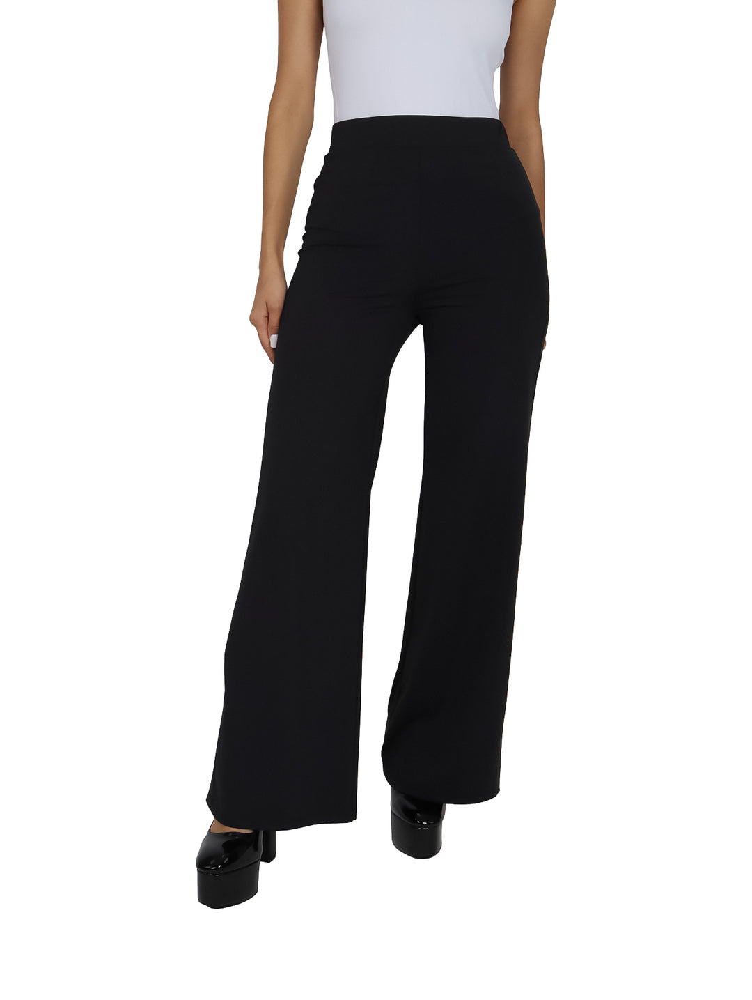 Mujer vistiendo un pantalón negro de pierna ancha y talle alto con zapatos de plataforma negros.