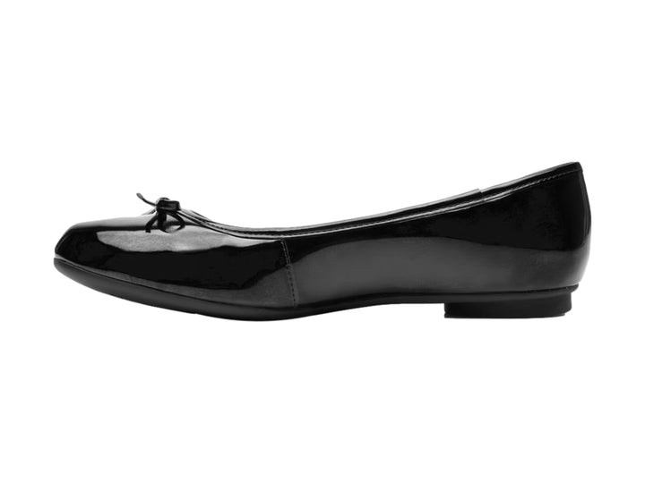 Zapato plano de charol negro con un pequeño moño decorativo en la punta.